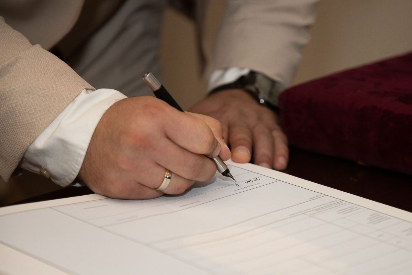 Two people reviewing and signing a document at a desk